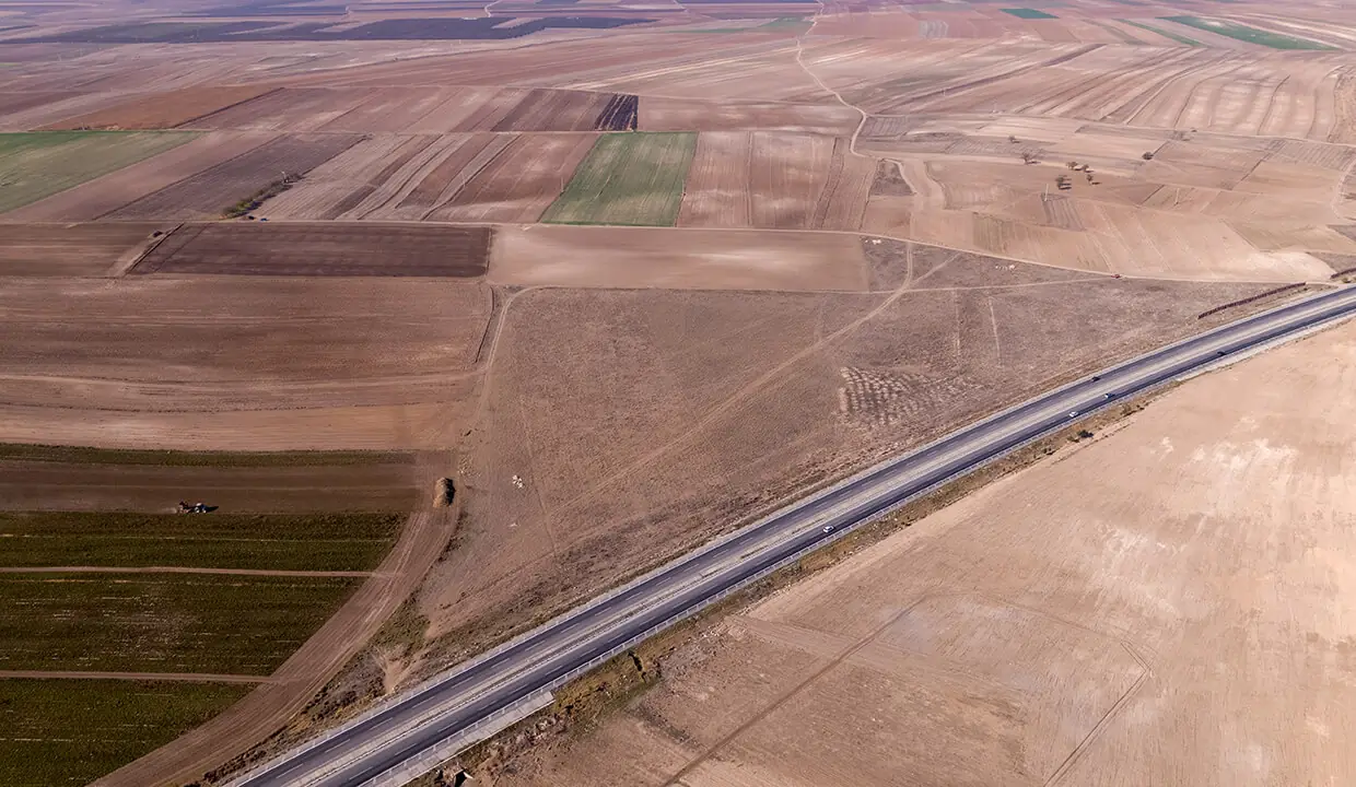 Arazinin çevresindeki tarım alanları ve yol, havadan