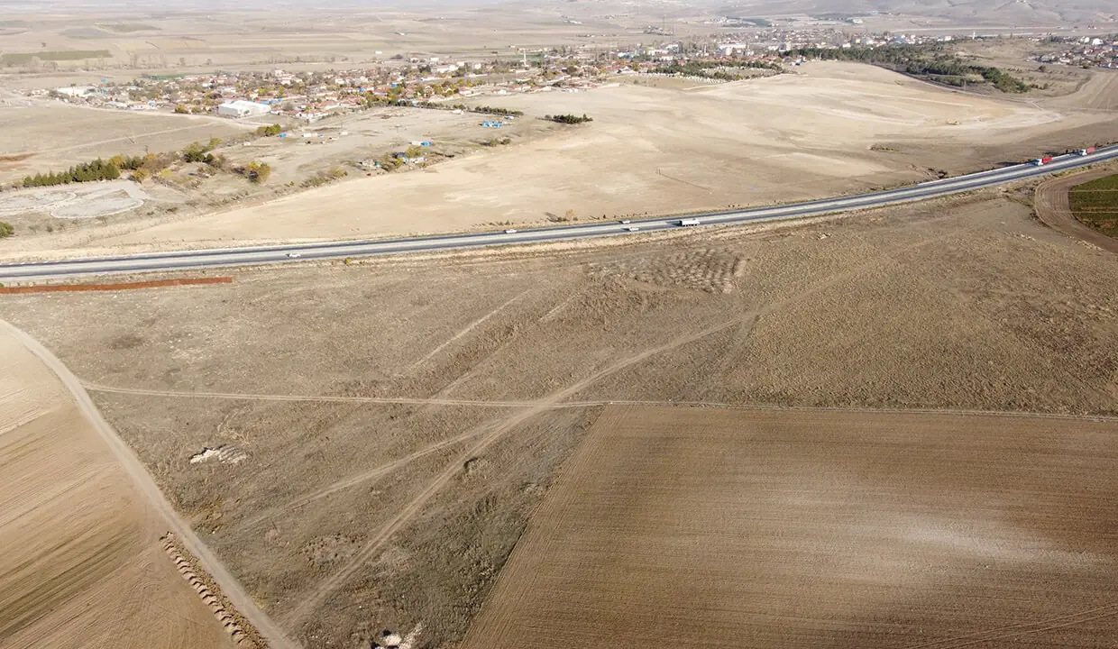Arazi ve yol cephesinin panoramik görünümü, arkada yerleşim